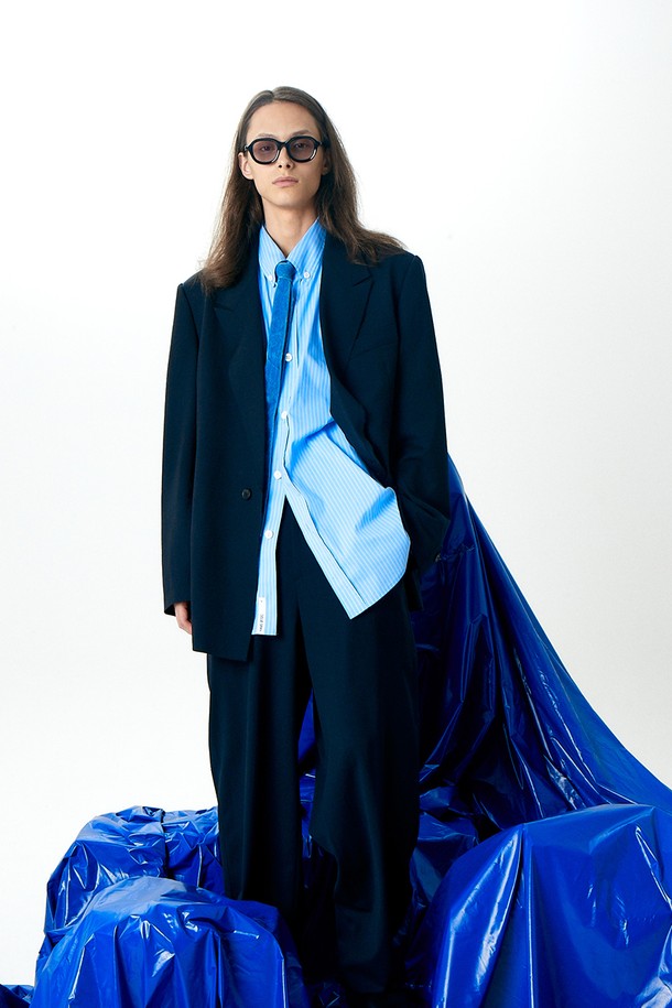 유니섹스 울 재킷 다크 네이비는 남녀 모두 착용 가능한 클래식하고 모던한 스타일의 자켓입니다. 가을, 겨울 시즌에 어울리는 두꺼운 두께감과 긴 소매 기장으로 따뜻하게 착용할 수 있습니다. 테일러드 코트 타입의 싱글 버튼 여밈 방식에 오버핏으로 제작되어 편안한 착용감을 선사합니다. 카라 디테일과 밑단 데끼 디테일, 안감의 스트라이프 패턴이 돋보입니다. 출근룩, 비즈니스 캐주얼, 모임룩 등 다양한 TPO에 활용하기 좋은 아이템입니다.
