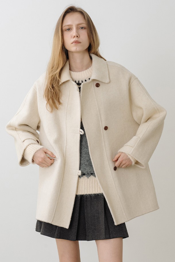 **울 100 핸드메이드 하프코트 CREAM BEIGE**

부드러운 촉감의 울 100% 소재로 제작된 여성 하프코트입니다. 미니멀하고 클래식한 무드의 크림베이지 컬러가 세련된 분위기를 연출하며, 루즈핏 디자인과 드롭 숄더 디테일로 편안한 착용감을 선사합니다. 싱글 버튼 여밈 방식과 구조적인 카라가 특징이며, 핸드메이드 공법으로 제작되어 높은 퀄리티를 자랑합니다. 겨울철 출근룩, 모임룩, 데이트룩 등 다양한 TPO에 레이어드하여 활용하기 좋은 아이템입니다.
