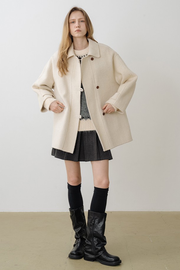 **울 100 핸드메이드 하프코트 CREAM BEIGE**

부드러운 촉감의 울 100% 소재로 제작된 여성 하프코트입니다. 미니멀하고 클래식한 무드의 크림베이지 컬러가 세련된 분위기를 연출하며, 루즈핏 디자인과 드롭 숄더 디테일로 편안한 착용감을 선사합니다. 싱글 버튼 여밈 방식과 구조적인 카라가 특징이며, 핸드메이드 공법으로 제작되어 높은 퀄리티를 자랑합니다. 겨울철 출근룩, 모임룩, 데이트룩 등 다양한 TPO에 레이어드하여 활용하기 좋은 아이템입니다.
