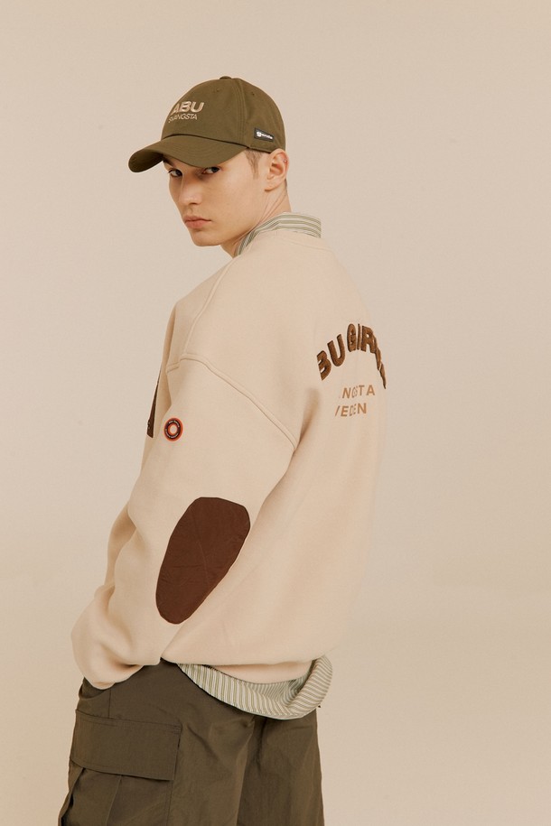 라이트 베이지 컬러의 부클 자수 맨투맨입니다. 면혼방 소재로 제작되어 부드러운 촉감을 선사하며, 캐주얼한 스타일을 연출하기 좋습니다. 뒷면에는 로고 부클 자수, 팔꿈치 패치 디자인, 소매단/밑단 립 처리, 소매 서클 와펜 등의 디테일이 돋보입니다. 라운드넥 디자인에 가슴 우측 지퍼 포켓이 있어 실용적이며, 봄, 여름 시즌 동네 마실룩, 여행룩, 소풍룩에 활용하기 좋습니다. 
