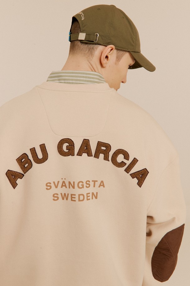 라이트 베이지 컬러의 부클 자수 맨투맨입니다. 면혼방 소재로 제작되어 부드러운 촉감을 선사하며, 캐주얼한 스타일을 연출하기 좋습니다. 뒷면에는 로고 부클 자수, 팔꿈치 패치 디자인, 소매단/밑단 립 처리, 소매 서클 와펜 등의 디테일이 돋보입니다. 라운드넥 디자인에 가슴 우측 지퍼 포켓이 있어 실용적이며, 봄, 여름 시즌 동네 마실룩, 여행룩, 소풍룩에 활용하기 좋습니다. 
