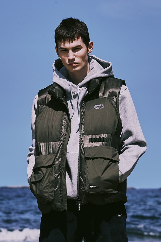 남성용 패브릭 콤비 포켓 다운 베스트 KHAKI(카키)입니다. 가을과 겨울에 착용하기 좋은 두꺼운 두께감의 패딩 베스트로, 일상 및 캐주얼 스타일을 연출하기에 적합합니다. 나일론과 폴리에스테르 혼방 소재로 제작되었으며, 레귤러 핏에 집업 방식으로 편안하게 착용할 수 있습니다. 스포티하면서도 캐주얼한 무드를 자아내며, 무지 디자인에 포켓 디테일이 더해져 실용성을 높였습니다. 민소매 디자인으로 다양한 레이어드 연출이 가능하며, 다운 충전재로 보온성을 강화했습니다.
