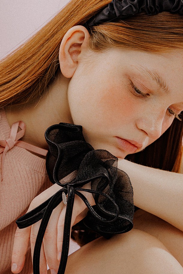 "리본 트리밍 시스루 스크런치 (블랙)"는 로맨틱하고 페미닌한 스타일을 연출하는 제품입니다. 시스루 원단과 새틴 트리밍, 리본 장식이 특징이며, 블랙 컬러로 세련된 분위기를 더합니다. 지름 16cm, 리본 13.5 x 17cm 사이즈로 제작되었으며, 브라스 소재의 메탈 디테일이 고급스러움을 더합니다. 데이트룩, 카페룩, 모임룩에 어울리며, 수작업으로 정교하게 제작되어 소장 가치를 높입니다.
