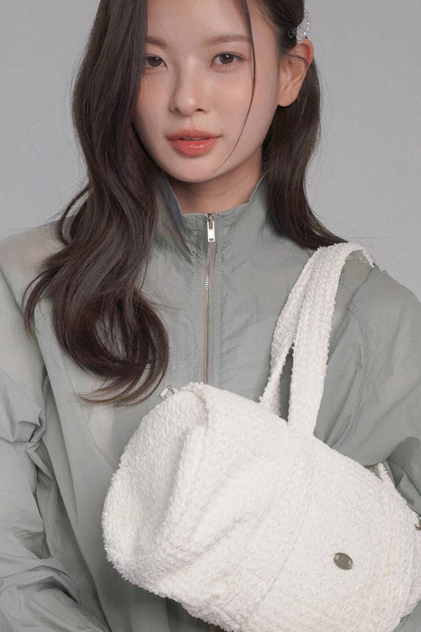 세련된 화이트 컬러의 패브릭 더플백입니다. 폴리에스테르, 나일론, 스판덱스 혼방 소재로 제작되어, 부드러운 라운드 텍스처와 푹신한 착용감을 선사합니다. 미디엄 사이즈의 무지 디자인으로, 더플 엠보싱과 키링 장식이 포인트를 더합니다. 손잡이와 사이드 포켓, 이중 손잡이, 토트백/숄더백 겸용, 내부 안감, 지퍼형 잠금 방식 등 실용적인 기능성을 갖췄습니다. 여행룩, 휴가룩, 피트니스룩 등 다양한 TPO에 캐주얼, 미니멀, 스포티 스타일을 연출할 수 있는 매력적인 아이템입니다.
