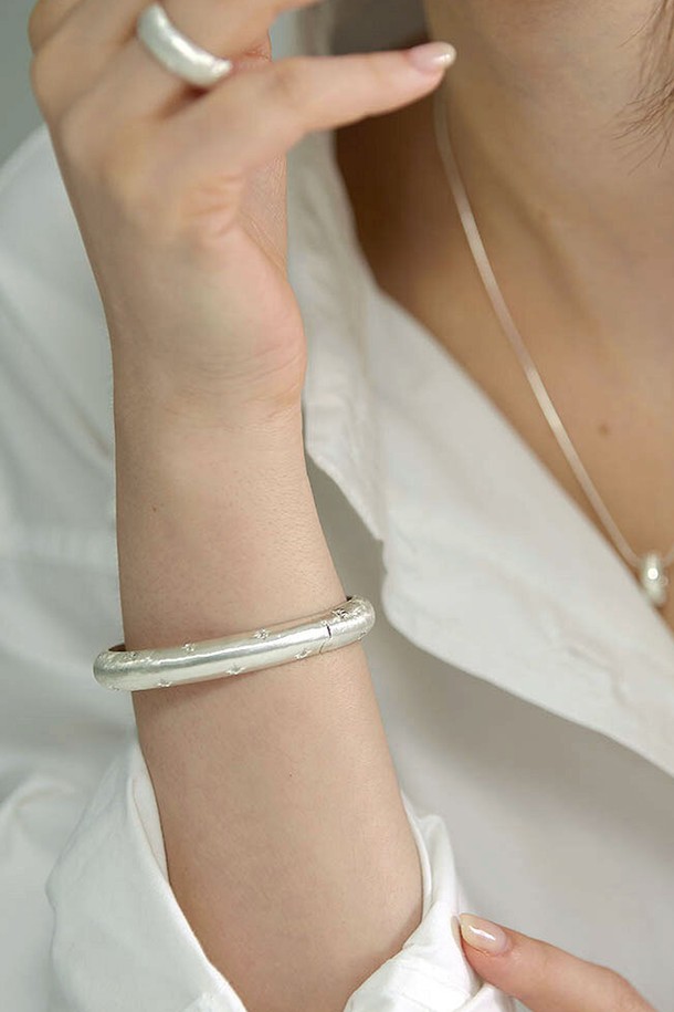 미니멀하고 세련된 매력의 "스텔라 뱅글 팔찌"입니다. 실버925 소재에 매트 표면 처리로 은은한 광택을 더했으며, 뱅글 스타일과 별 모티프 디자인이 돋보입니다. 불륨감 있는 디자인과 단독 착용만으로도 포인트를 줄 수 있어 데이트룩, 모임룩 등 다양한 스타일에 활용하기 좋습니다. 주물 제작 상품으로, 미세 기포가 발생할 수 있으며, 제작 기간은 7~14일 소요됩니다. 8-5mm의 적절한 사이즈로 편안하게 착용할 수 있습니다.
