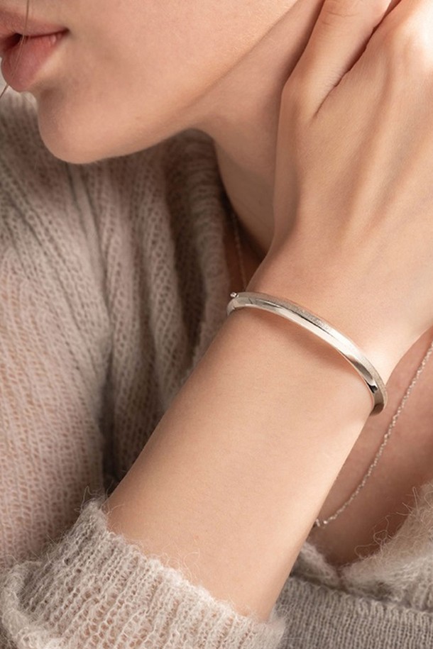 세련된 실버 뱅글 팔찌입니다. 날렵하게 꺾인 각진 라인이 돋보이며, 모던하고 시크한 스타일을 연출합니다. 925 실버 소재로 제작되었으며, 두 가지 표면 처리 기법으로 입체감을 더했습니다. 18-19cm 길이로, 데이트룩이나 모임룩에 포인트 아이템으로 활용하기 좋습니다. 주물 제작 특성상 미세한 기포가 발생할 수 있으며, 제품 검수 및 포장 과정은 CCTV/동영상으로 기록됩니다.
