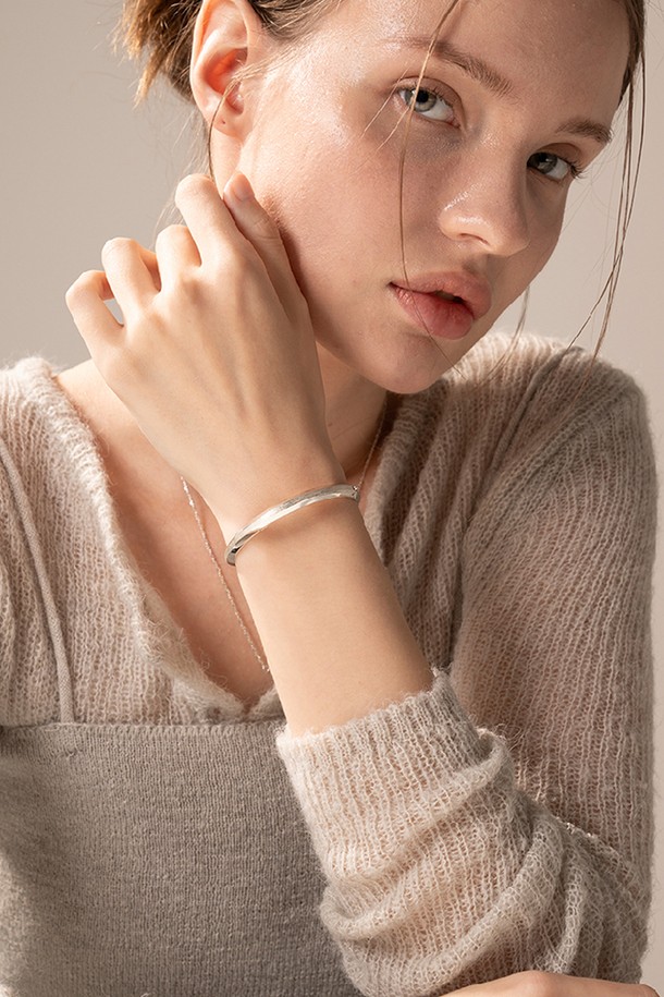 세련된 실버 뱅글 팔찌입니다. 날렵하게 꺾인 각진 라인이 돋보이며, 모던하고 시크한 스타일을 연출합니다. 925 실버 소재로 제작되었으며, 두 가지 표면 처리 기법으로 입체감을 더했습니다. 18-19cm 길이로, 데이트룩이나 모임룩에 포인트 아이템으로 활용하기 좋습니다. 주물 제작 특성상 미세한 기포가 발생할 수 있으며, 제품 검수 및 포장 과정은 CCTV/동영상으로 기록됩니다.
