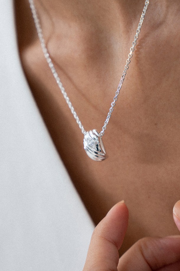 멜로디 라인 네크리스 목걸이 silver는 여성스러운 매력을 더해줄 실버 925 소재의 목걸이입니다. 실린더 형태의 펜던트에 대각선 곡선 디자인과 3개의 작은 큐빅 지르코니아 스톤이 세팅되어 은은하게 빛납니다. 미니멀하면서도 모던한 스타일로, 유기적인 곡선과 입체적인 부조 효과가 돋보입니다. 데이트룩, 모임룩, 소개팅룩에 잘 어울리며, 다양한 스타일에 매치하여 시크하고 클래식한 분위기를 연출할 수 있습니다. 43cm에 4cm 연장 체인으로 길이 조절이 가능하며, 10만원 미만 구매 시 기본 패키지, 10만원 이상 구매 시 프리미엄 패키지로 제공됩니다.
