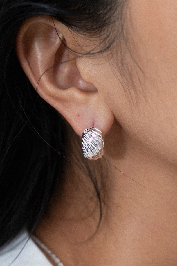 멜로디 라인 이어링 실버는 여성스러움을 극대화하는 이어링입니다. 실버925 소재에 큐빅 지르코니아를 세팅하여 은은하게 빛나며, 귀를 감싸는 곡선 실루엣이 특징입니다. 입체적인 대각선 패턴이 빛을 반사하여 화려함을 더하고, 중앙의 스톤이 포인트를 더해줍니다. 데이트룩, 모임룩, 오피스룩 등 다양한 TPO에 미니멀, 클래식, 시크한 스타일을 연출할 수 있는 세련된 디자인입니다. 사이즈는 9mm x 15mm입니다.
