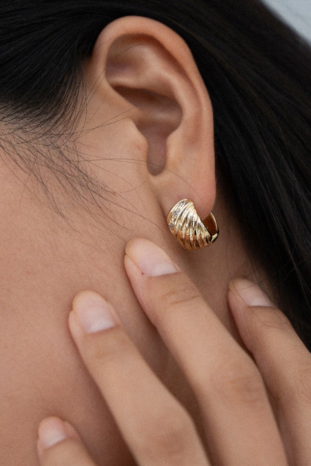 멜로디 라인 이어링 14K 골드 도금은 여성스러운 매력을 더해주는 이어링입니다. 입체적인 대각선 패턴과 중앙 큐빅지르코니아 스톤 장식이 빛 반사 효과를 주어 더욱 화려하게 빛납니다. 귀를 감싸는 곡선 실루엣 디자인은 심플하면서도 특징적인 포인트를 선사하며, 9mm x 15mm 사이즈로 데일리룩과 포멀룩에 모두 잘 어울립니다. 14K 골드 도금 마감으로 고급스러움을 더했으며, 미니멀하면서도 엘레강스한 스타일을 연출하여 모임룩이나 오피스룩에 활용하기 좋습니다.
