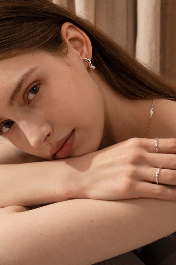 **웨이브 블룸 이어링**은 자연스러운 곡선 디자인이 돋보이는 여성용 이어링입니다. 실버925 소재에 큐빅 지르코니아를 세팅하여 은은한 광택을 더했으며, 매트한 실버 표면 질감이 고급스러운 분위기를 자아냅니다. 미니멀하면서도 우아한 스타일로, 데이트룩이나 카페룩에 세련된 포인트를 줄 수 있습니다. 심플한 디자인과 불규칙한 표면 질감이 조화롭게 어우러져 일상 속 특별함을 선사합니다.
