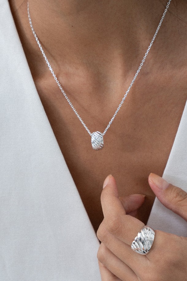 멜로디 라인 네크리스 목걸이 silver는 여성스러운 매력을 더해줄 실버 925 소재의 목걸이입니다. 실린더 형태의 펜던트에 대각선 곡선 디자인과 3개의 작은 큐빅 지르코니아 스톤이 세팅되어 은은하게 빛납니다. 미니멀하면서도 모던한 스타일로, 유기적인 곡선과 입체적인 부조 효과가 돋보입니다. 데이트룩, 모임룩, 소개팅룩에 잘 어울리며, 다양한 스타일에 매치하여 시크하고 클래식한 분위기를 연출할 수 있습니다. 43cm에 4cm 연장 체인으로 길이 조절이 가능하며, 10만원 미만 구매 시 기본 패키지, 10만원 이상 구매 시 프리미엄 패키지로 제공됩니다.
