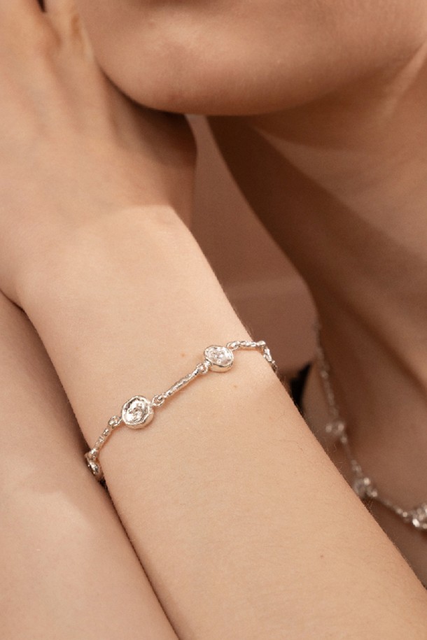 **아트클립 팔찌**는 미니멀하고 베이직한 스타일을 추구하는 여성분을 위한 실버 팔찌입니다. 유기적인 곡선 디자인과 불규칙한 실루엣이 특징이며, 입체적인 텍스처와 자연스러운 광택으로 세련된 분위기를 더합니다. 팔찌 전체에 큐빅 지르코니아 장식을 더하여 은은한 반짝임을 선사하며, 데일리룩과 오피스룩에 모두 잘 어울립니다. 실버925 소재로 제작되어 고급스러움을 더했으며, 약 8mm의 사이즈로 부담 없이 착용할 수 있습니다. 수공예적인 느낌을 살려 특별함을 더했습니다.
