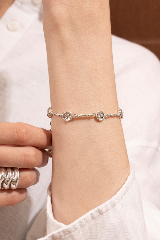 **아트클립 팔찌**는 미니멀하고 베이직한 스타일을 추구하는 여성분을 위한 실버 팔찌입니다. 유기적인 곡선 디자인과 불규칙한 실루엣이 특징이며, 입체적인 텍스처와 자연스러운 광택으로 세련된 분위기를 더합니다. 팔찌 전체에 큐빅 지르코니아 장식을 더하여 은은한 반짝임을 선사하며, 데일리룩과 오피스룩에 모두 잘 어울립니다. 실버925 소재로 제작되어 고급스러움을 더했으며, 약 8mm의 사이즈로 부담 없이 착용할 수 있습니다. 수공예적인 느낌을 살려 특별함을 더했습니다.
