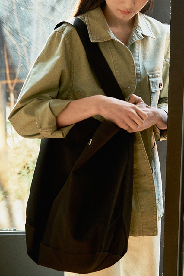 블랙 컬러의 원숄더 캔버스 백입니다. 넉넉한 수납력을 자랑하는 라지 사이즈로, 무지 디자인에 자수 디테일이 더해져 심플하면서도 세련된 느낌을 줍니다. 면 소재로 제작되어 사계절 내내 편안하게 사용할 수 있으며, 내부 포켓으로 실용성을 높였습니다. 조임용 끈으로 내용물을 안전하게 보관할 수 있으며, 캐주얼, 미니멀, 클래식 스타일의 동네 마실룩, 쇼핑룩, 여행룩에 잘 어울립니다.
