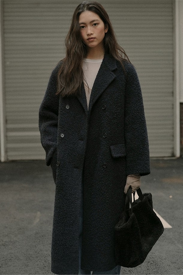 [블랭크03] 수리 알파카 핸드메이드 더블 코트 (딥 네이비)는 부드러운 촉감과 고급스러운 광택이 돋보이는 여성용 코트입니다. 클래식과 미니멀한 스타일을 추구하는 분들을 위한 롱 기장의 더블코트로, 오피스룩, 출근룩, 모임룩 등 다양한 TPO에 활용 가능합니다. 프리미엄 수리 알파카 소재와 울, 나일론 혼방으로 제작되어 보온성과 방풍 기능이 뛰어나 겨울철에도 따뜻하게 착용할 수 있습니다. 실크 테이프 마감, 혼 단추 사용, 안감 처리 등 섬세한 디테일이 돋보이며, 루즈핏으로 편안한 착용감을 선사합니다. 
