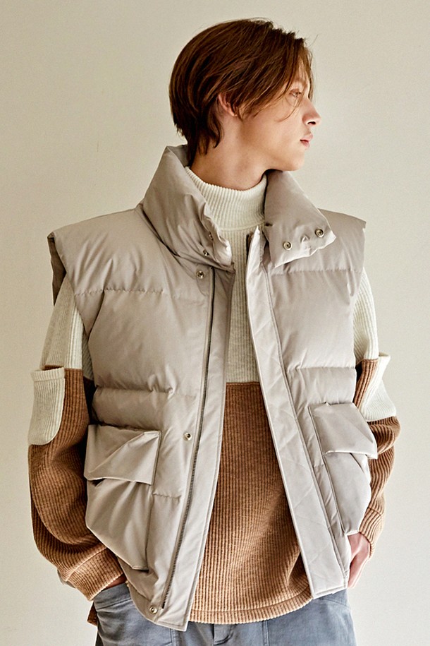 오버숄더 입체포켓 오버핏 밴드넥 다운 베스트 CTS22WWDVB51 BEI는 포근한 겨울 스타일을 완성하는 베이지 컬러의 다운 베스트입니다. 데일리, 캐주얼, 출퇴근, 데이트 등 다양한 TPO에 활용하기 좋으며, 미니멀하고 캐주얼한 무드를 연출합니다. 하이넥 디자인과 유니크한 숄더라인이 돋보이며, 입체 포켓 디테일로 수납성을 더했습니다. 부드러운 촉감의 폴리에스테르와 덕다운 소재를 사용하여 보온성을 높였으며, 깃털 빠짐 현상을 최소화했습니다. 오버핏과 퀼팅 무늬가 특징인 하프 기장의 베스트로, 스냅 버튼으로 간편하게 여밀 수 있습니다.
