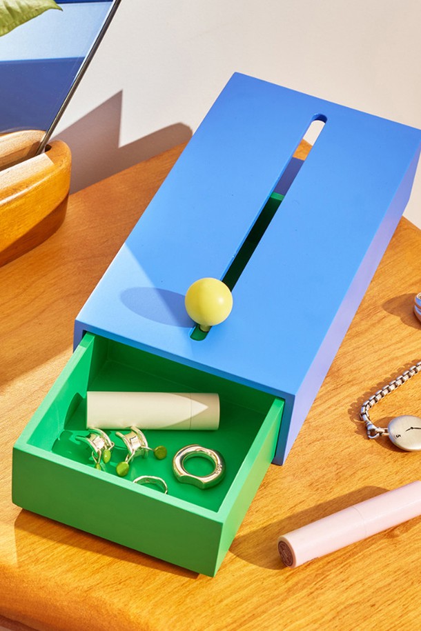 [에어리어웨어] 캐쉬박스는 미니멀한 디자인의 수납함으로, 블루, 그린, 옐로우 세 가지 색상으로 제공됩니다. MDF 소재로 제작되었으며, 손잡이와 슬라이딩 기능이 있어 실용적입니다. 상단 개폐구와 다용도 수납 공간을 갖춰 데코레이션 용도로도 활용 가능합니다.
