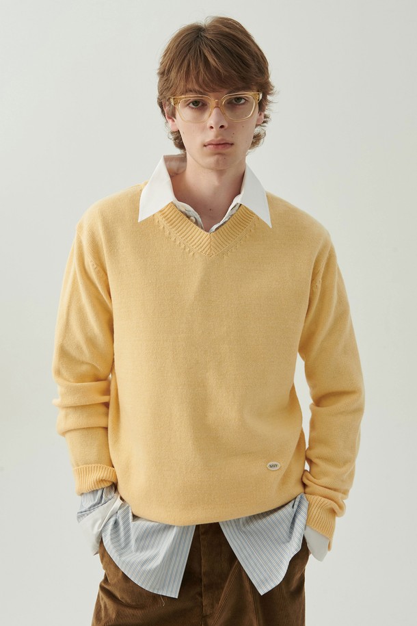 헤리티지 브이넥 울 니트 옐로우는 남녀 모두 착용 가능한 유니섹스 디자인의 니트/스웨터입니다. 메리노 울 혼방 원사를 사용하여 부드러운 촉감을 자랑하며, 가을과 겨울에 따뜻하게 입을 수 있습니다. 옐로우와 그레이 두 가지 컬러로 만나볼 수 있으며, 레귤러핏과 긴소매 기장으로 제작되었습니다. 소매 커프스에는 진주 단추 디테일과 인조 진주 메달이 더해져 클래식하고 베이직한 무드를 연출합니다. 데이트룩, 카페룩, 겨울 데일리룩 등 다양한 TPO에 활용할 수 있습니다.
