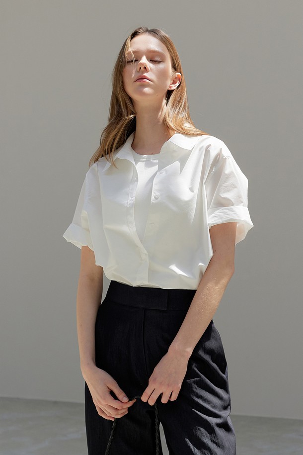 Feminine Shirt_아이보리 셔츠는 모던하고 세련된 실루엣을 자랑하는 여성 셔츠/블라우스입니다. 아이보리 및 버터베이지 컬러로 출시되어 부드럽고 우아한 분위기를 연출하며, 봄, 여름 계절에 데이트룩, 카페룩, 출근룩 등 다양한 TPO에 활용하기 좋습니다. 루즈핏과 라운드넥 디자인으로 편안한 착용감을 제공하며, 클래식하고 미니멀한 스타일을 선호하는 분들께 적합합니다. 폴리에스터와 면 혼방 소재로 제작되어 부드러운 촉감을 선사하며, 무지 패턴의 반소매 디자인으로 어떤 하의와도 쉽게 매치할 수 있습니다.
