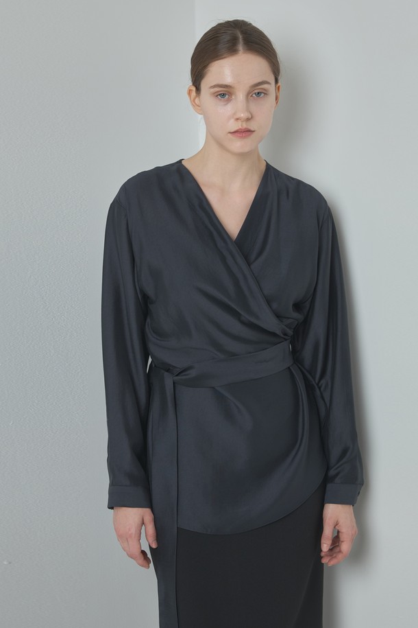 Wrap Blouse_다크 그레이는 여성 의류 상의로, 모던하고 세련된 스타일을 연출합니다. 부드러운 모달과 폴리에스터 혼방 소재로 제작되어 편안한 착용감을 선사하며, 랩넥 디자인과 램 포인트 디테일이 특징입니다. 미니멀하면서도 베이직한 디자인으로 데이트룩이나 오피스룩 등 다양한 TPO에 활용하기 좋습니다. 다크 그레이, 아이보리, 브라운 세 가지 컬러로 출시되어 취향에 맞게 선택 가능하며, 봄, 가을 시즌에 적합한 긴 소매 레귤러핏 블라우스입니다.
