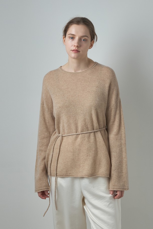 베이지 색상의 Belted Round Cashmere Knit (벨티드 라운드 캐시미어 니트)는 여성용 니트/스웨터입니다. 부드러운 캐시미어 소재로 제작되어 가을과 겨울에 따뜻하게 착용할 수 있으며, 두꺼운 두께감으로 포근함을 더합니다. 라운드넥과 긴 소매, 레귤러핏 디자인으로 미니멀하고 베이직한 스타일을 연출하며, 벨트 디테일이 포인트입니다. 출근룩과 모임룩에 활용하기 좋은 아이템입니다.
