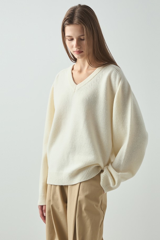 아이보리 컬러의 에센셜 니트입니다. 여성 의류로, 가을과 겨울에 따뜻하게 착용하기 좋은 두꺼운 두께감의 V넥 니트입니다. 울과 아크릴 혼방 소재로 부드러운 촉감을 선사하며, 베이직하고 미니멀한 스타일을 연출합니다. 루즈핏과 볼륨 소매 디자인으로 편안하면서도 세련된 느낌을 더했습니다. 무지 패턴의 긴소매 디자인으로 다양한 룩에 활용하기 좋습니다.
