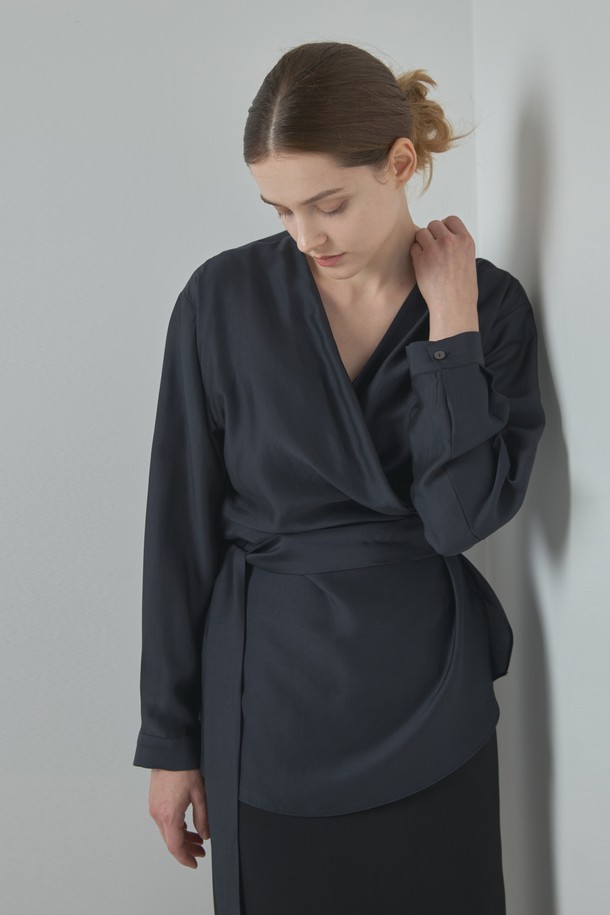 Wrap Blouse_다크 그레이는 여성 의류 상의로, 모던하고 세련된 스타일을 연출합니다. 부드러운 모달과 폴리에스터 혼방 소재로 제작되어 편안한 착용감을 선사하며, 랩넥 디자인과 램 포인트 디테일이 특징입니다. 미니멀하면서도 베이직한 디자인으로 데이트룩이나 오피스룩 등 다양한 TPO에 활용하기 좋습니다. 다크 그레이, 아이보리, 브라운 세 가지 컬러로 출시되어 취향에 맞게 선택 가능하며, 봄, 가을 시즌에 적합한 긴 소매 레귤러핏 블라우스입니다.
