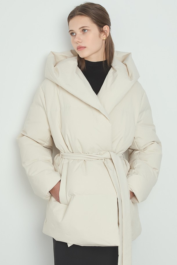 포근한 겨울을 위한 여성용 "클라우드 패딩_아이보리"입니다. 미니멀하고 캐주얼한 스타일로, 부드러운 촉감의 폴리에스테르 소재와 두꺼운 두께감으로 따뜻함을 선사합니다. 오버핏 디자인에 긴 소매, 후드, 벨트 디테일이 더해져 멋스러운 실루엣을 연출합니다. 허리 벨트로 다양한 스타일을 연출할 수 있으며, 안감은 패딩 처리되어 보온성을 높였습니다. 넉넉한 기장의 미디엄 기장 패딩으로, 겨울철 일상에서 편안하게 착용하기 좋습니다.
