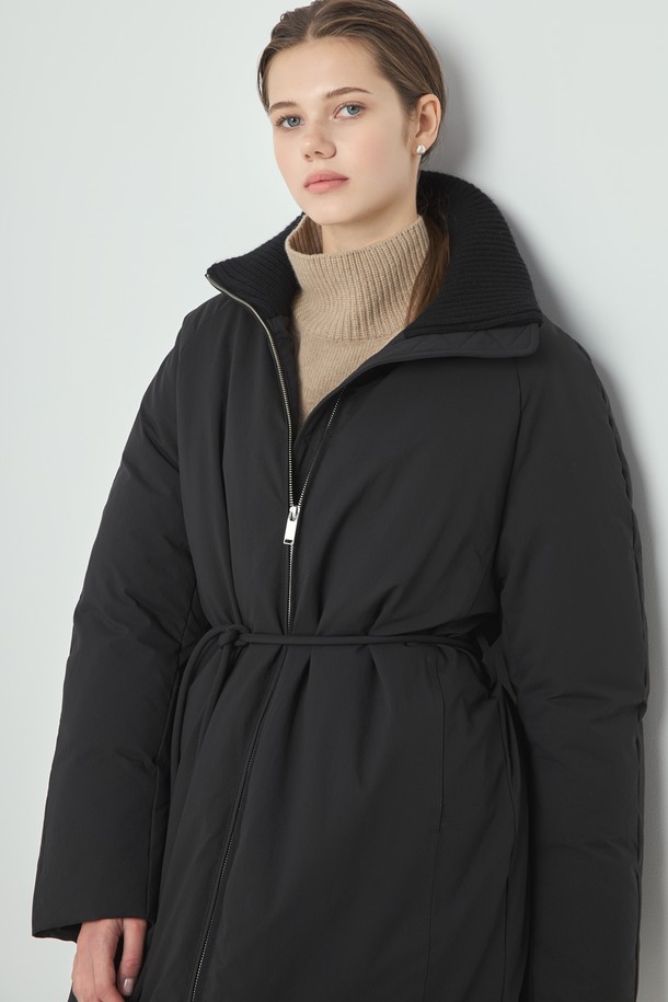 Knit Long Padding (니트 롱 패딩)_Black은 여성용 아우터로, 겨울철 출근룩을 위한 미니멀하고 모던한 스타일을 제안합니다. 블랙과 아이보리 두 가지 색상으로 출시되었으며, 롱 기장에 오버핏으로 편안한 착용감을 선사합니다. 부드러운 촉감의 폴리에스테르, 울, 나일론 혼방 소재에 구스다운 80%와 페더 20% 충전재, 700FP의 높은 필파워로 뛰어난 보온성을 자랑합니다. 하이넥 디자인과 벨트 여밈 방식으로 시크하고 클래식한 분위기를 연출하며, 니트 배색 디테일로 포인트를 더했습니다. 긴 소매 기장의 두꺼운 패딩으로 한겨울 추위에도 따뜻하게 스타일을 완성할 수 있습니다.
