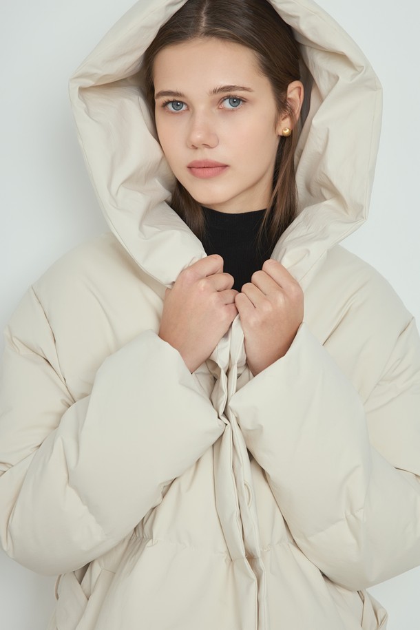 포근한 겨울을 위한 여성용 "클라우드 패딩_아이보리"입니다. 미니멀하고 캐주얼한 스타일로, 부드러운 촉감의 폴리에스테르 소재와 두꺼운 두께감으로 따뜻함을 선사합니다. 오버핏 디자인에 긴 소매, 후드, 벨트 디테일이 더해져 멋스러운 실루엣을 연출합니다. 허리 벨트로 다양한 스타일을 연출할 수 있으며, 안감은 패딩 처리되어 보온성을 높였습니다. 넉넉한 기장의 미디엄 기장 패딩으로, 겨울철 일상에서 편안하게 착용하기 좋습니다.
