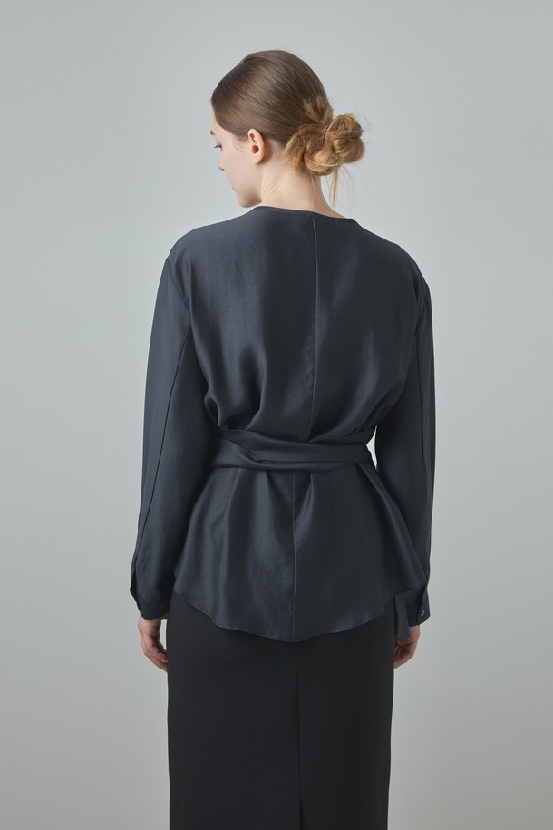 Wrap Blouse_다크 그레이는 여성 의류 상의로, 모던하고 세련된 스타일을 연출합니다. 부드러운 모달과 폴리에스터 혼방 소재로 제작되어 편안한 착용감을 선사하며, 랩넥 디자인과 램 포인트 디테일이 특징입니다. 미니멀하면서도 베이직한 디자인으로 데이트룩이나 오피스룩 등 다양한 TPO에 활용하기 좋습니다. 다크 그레이, 아이보리, 브라운 세 가지 컬러로 출시되어 취향에 맞게 선택 가능하며, 봄, 가을 시즌에 적합한 긴 소매 레귤러핏 블라우스입니다.
