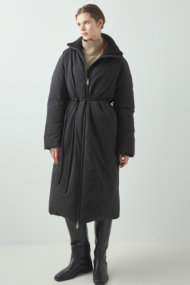 Knit Long Padding (니트 롱 패딩)_Black은 여성용 아우터로, 겨울철 출근룩을 위한 미니멀하고 모던한 스타일을 제안합니다. 블랙과 아이보리 두 가지 색상으로 출시되었으며, 롱 기장에 오버핏으로 편안한 착용감을 선사합니다. 부드러운 촉감의 폴리에스테르, 울, 나일론 혼방 소재에 구스다운 80%와 페더 20% 충전재, 700FP의 높은 필파워로 뛰어난 보온성을 자랑합니다. 하이넥 디자인과 벨트 여밈 방식으로 시크하고 클래식한 분위기를 연출하며, 니트 배색 디테일로 포인트를 더했습니다. 긴 소매 기장의 두꺼운 패딩으로 한겨울 추위에도 따뜻하게 스타일을 완성할 수 있습니다.
