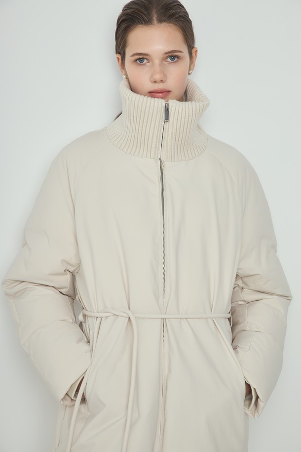 아이보리 컬러의 Knit Long 패딩은 여성 의류로, 겨울철 일상과 출근룩에 적합한 롱패딩입니다. 미니멀하고 베이직한 스타일을 추구하며, 부드러운 촉감의 폴리에스테르, 울, 나일론 혼방 소재로 제작되었습니다. 하이넥 디자인과 니트 배색 디테일, 벨트 디테일이 돋보이며, 700FP 구스다운 충전재와 안감으로 따뜻함을 더했습니다. 긴소매, 집업 여밈 방식, 레귤러핏으로 편안하게 착용 가능합니다.
