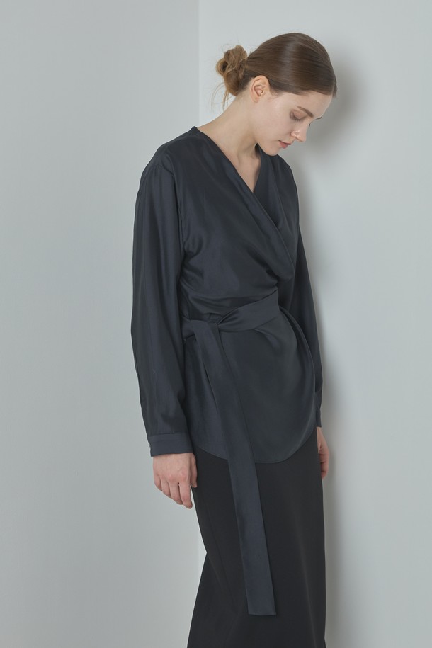 Wrap Blouse_다크 그레이는 여성 의류 상의로, 모던하고 세련된 스타일을 연출합니다. 부드러운 모달과 폴리에스터 혼방 소재로 제작되어 편안한 착용감을 선사하며, 랩넥 디자인과 램 포인트 디테일이 특징입니다. 미니멀하면서도 베이직한 디자인으로 데이트룩이나 오피스룩 등 다양한 TPO에 활용하기 좋습니다. 다크 그레이, 아이보리, 브라운 세 가지 컬러로 출시되어 취향에 맞게 선택 가능하며, 봄, 가을 시즌에 적합한 긴 소매 레귤러핏 블라우스입니다.
