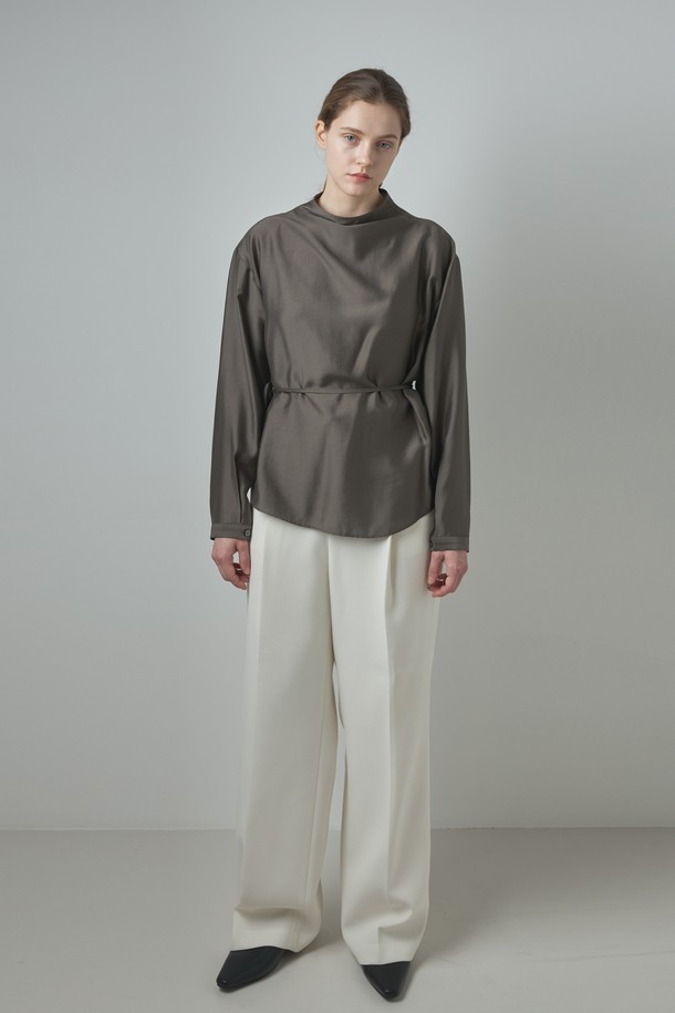 Lea 블라우스_카키 브라운은 모던하고 미니멀한 스타일을 추구하는 여성들을 위한 상의 블라우스입니다. 부드러운 모달과 폴리에스테르 혼방 소재로 제작되어 봄, 가을에 착용하기 좋으며, 얇은 두께감으로 편안한 착용감을 선사합니다. 하프넥 디자인과 허리 스트랩 디테일이 특징이며, 투웨이 스타일링이 가능하여 다양한 연출을 즐길 수 있습니다. 드레이프 네크라인과 은은한 광택감이 고급스러운 분위기를 더하며, 데이트룩, 오피스룩, 모임룩 등 다양한 TPO에 활용 가능합니다. 차분한 카키 브라운, 아이보리, 다크 그레이 컬러로 출시되어 클래식, 미니멀, 시크한 스타일을 연출하기에 좋습니다.
