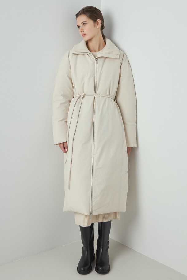 아이보리 컬러의 Knit Long 패딩은 여성 의류로, 겨울철 일상과 출근룩에 적합한 롱패딩입니다. 미니멀하고 베이직한 스타일을 추구하며, 부드러운 촉감의 폴리에스테르, 울, 나일론 혼방 소재로 제작되었습니다. 하이넥 디자인과 니트 배색 디테일, 벨트 디테일이 돋보이며, 700FP 구스다운 충전재와 안감으로 따뜻함을 더했습니다. 긴소매, 집업 여밈 방식, 레귤러핏으로 편안하게 착용 가능합니다.
