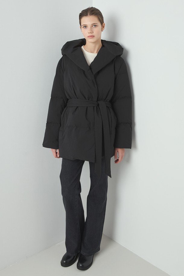 Cloud 패딩_블랙은 겨울철 여성의 우아함과 따뜻함을 책임지는 롱 기장의 오버핏 패딩 점퍼입니다. 부드러운 촉감의 폴리에스테르 소재로 제작되었으며, 두꺼운 두께감과 퀼팅 안감으로 뛰어난 보온성을 제공합니다. 미니멀하고 베이직한 디자인으로 출근룩이나 모임룩 등 다양한 TPO에 활용 가능하며, 벨트 디테일과 후드가 더해져 스타일리시함을 더합니다. 긴 소매, 무지 패턴, 블랙 컬러로 어떤 스타일에도 쉽게 매치할 수 있으며, 클래식, 캐주얼 무드를 연출하기 좋습니다.
