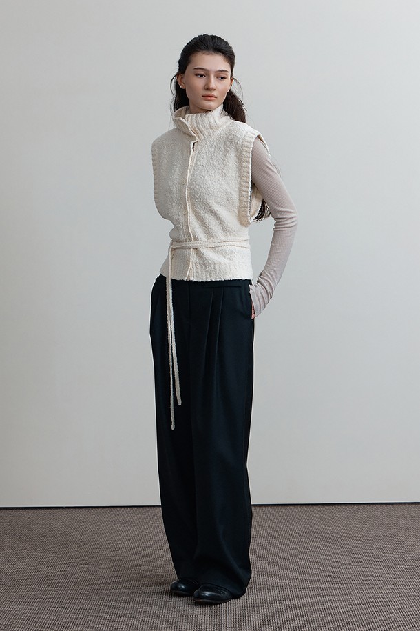 **RIONA KNIT, 아이보리**

부드러운 촉감의 RIONA KNIT, 아이보리 베스트입니다. 여성 의류로, 가을과 겨울에 따뜻하게 착용하기 좋은 두꺼운 두께감의 민소매 제품입니다. 루즈핏으로 편안하게 착용 가능하며, 무지 패턴에 오픈 카라 또는 카울넥으로 연출할 수 있는 네크라인 디자인이 특징입니다. 스트랩 디테일과 레이어링이 용이하여 다양한 스타일을 연출할 수 있으며, 캐주얼, 클래식, 미니멀 스타일의 겨울 데일리룩에 활용하기 좋습니다.
