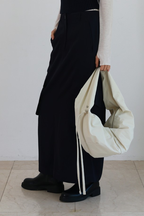 "LUVIN BAG LARGE NYLON IVORY 러빈백 라지 나일론 아이보리"는 부드러운 터치감과 생활 방수가 가능한 여성용 숄더백입니다. 아이보리 컬러의 무지 디자인에 하트 모양으로 러블리함을 더했으며, 주름 디테일로 포인트를 주었습니다. 넉넉한 수납 공간과 숄더 스트랩, D링 장식이 있어 실용적입니다. 미니멀, 캐주얼, 걸리시 스타일을 즐기는 분들께 데이트룩, 쇼핑룩, 카페룩에 매치하기 좋은 아이템입니다. 지퍼형 잠금 방식으로 소지품을 안전하게 보관할 수 있습니다.
