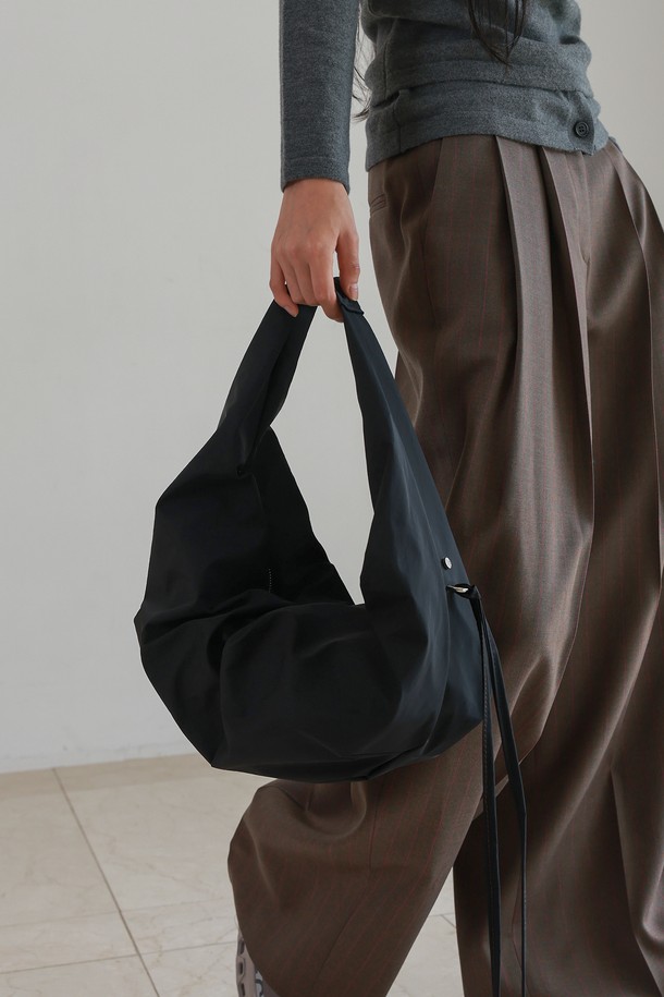 **LUVIN BAG LARGE NYLON BLACK 러빈백 라지 나일론 블랙**은 가볍고 방수 기능이 뛰어난 여성 숄더백입니다. 부드러운 텍스처와 자연스러운 드레이프성이 특징이며, 하트 모양의 디자인과 지퍼 및 D링 장식이 돋보입니다. 넉넉한 수납을 위한 라지 사이즈로, 내부 포켓과 외부 D링이 있어 실용적입니다. 센터 플리팅 디테일이 더해져 미니멀, 캐주얼, 시크한 스타일을 연출하며 데이트룩, 쇼핑룩, 카페룩에 잘 어울립니다. 블랙 컬러의 무지 디자인으로 어떤 룩에도 매치하기 좋습니다.
