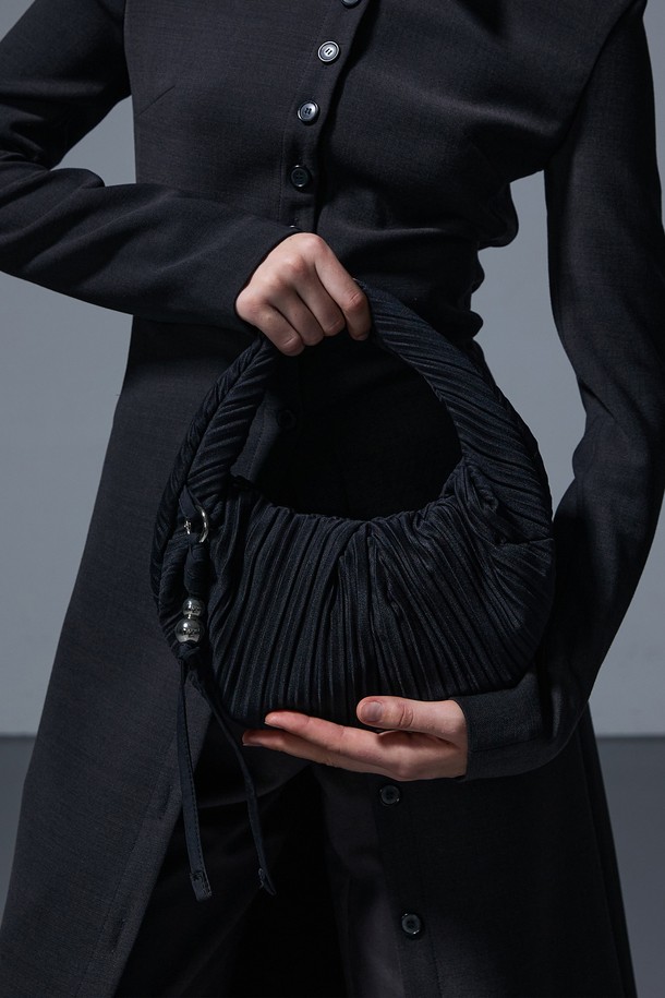 러비츠백 스몰 블랙은 부드러운 주름 디자인이 돋보이는 여성 숄더백 겸 크로스백입니다. 캐주얼하고 미니멀한 스타일을 연출하기 좋으며, 일상생활에서 활용하기 적합합니다. 가방은 스몰 사이즈로 소지품을 간편하게 수납할 수 있으며, 지퍼로 안전하게 여닫을 수 있습니다. 블랙 컬러의 폴리에스테르 소재로 제작되어 내구성이 뛰어나고 관리도 용이합니다. 반원 형태의 디자인이 세련된 느낌을 더합니다.
