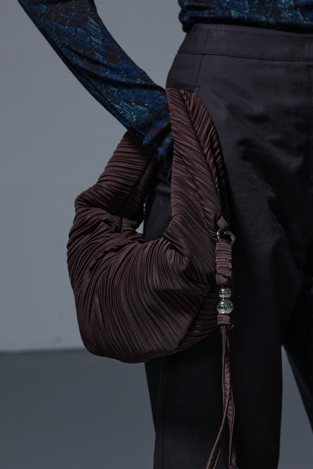 러비츠백 스몰 브라운은 여성스러운 매력을 더하는 가방입니다. 부드러운 브라운 컬러의 반원 형태에 플리츠 주름 디테일이 돋보이며, 크로스백으로 활용하여 편안하게 연출할 수 있습니다. 지퍼형 잠금 방식으로 소지품을 안전하게 보관할 수 있습니다. 미니멀, 클래식, 걸리시 스타일을 즐겨 입는 분들께 데이트룩, 모임룩에 포인트를 더하는 아이템입니다. 스몰 사이즈로, 콤팩트하면서도 세련된 스타일을 완성합니다.
