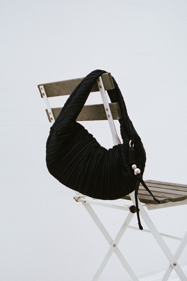 러비츠백 스몰 블랙은 부드러운 주름 디자인이 돋보이는 여성 숄더백 겸 크로스백입니다. 캐주얼하고 미니멀한 스타일을 연출하기 좋으며, 일상생활에서 활용하기 적합합니다. 가방은 스몰 사이즈로 소지품을 간편하게 수납할 수 있으며, 지퍼로 안전하게 여닫을 수 있습니다. 블랙 컬러의 폴리에스테르 소재로 제작되어 내구성이 뛰어나고 관리도 용이합니다. 반원 형태의 디자인이 세련된 느낌을 더합니다.
