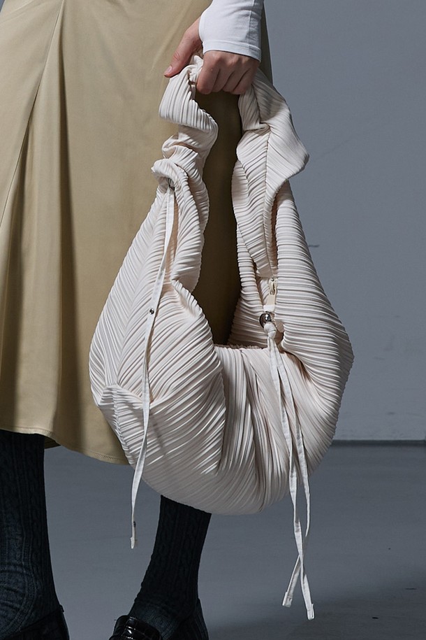 LUVITS BAG LARGE IVORY (러비츠백 라지 아이보리)는 여성스러운 데이트룩과 모임룩을 위한 숄더백입니다. 미니멀하면서도 클래식한 스타일을 추구하며, 아이보리 컬러와 무지 디자인으로 어떤 옷에도 잘 어울립니다. 라지 사이즈의 반원 모양 가방으로, 드레이핑 및 플리츠 디테일이 돋보입니다. 
