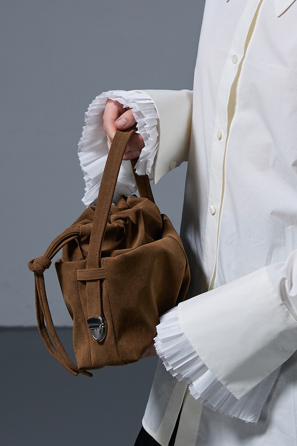 DEAR BAG SMALL SUEDE CAMEL (디어백 스몰 스웨이드 카멜) 숄더백은 부드러운 스웨이드 소재의 카멜 컬러로, 미니멀하면서도 클래식한 스타일을 연출합니다. 가방 전면에 리본 디테일이 여성스러운 포인트를 더하며, 사각 쉐입과 숄더 스트랩으로 실용성을 높였습니다. 마그네틱 잠금 방식으로 간편하게 여닫을 수 있어 데이트룩, 모임룩 등 다양한 TPO에 활용 가능합니다. 디어백 시리즈 특유의 세련된 디자인으로 일상 속에서 스타일리시함을 더해보세요.
