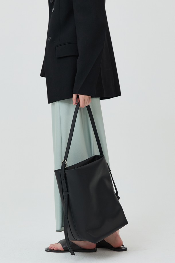 BUTLER BAG (버틀러백) 소가죽 블랙은 부드러운 소가죽 소재로 제작된 미디엄 사이즈의 버킷 백입니다. 버클 디테일과 가죽 스트랩 타이로 포인트를 주어 클래식하면서도 시크한 무드를 연출합니다. 내부 포켓이 있어 수납력을 높였으며, 숄더백과 크로스백으로 활용 가능한 조절 가능한 스트랩을 갖추었습니다. 데이트룩, 오피스룩 등 TPO에 구애받지 않고 미니멀한 스타일을 완성하는 데일리 백입니다. 고리형 잠금 방식으로 간편하게 여닫을 수 있습니다.
