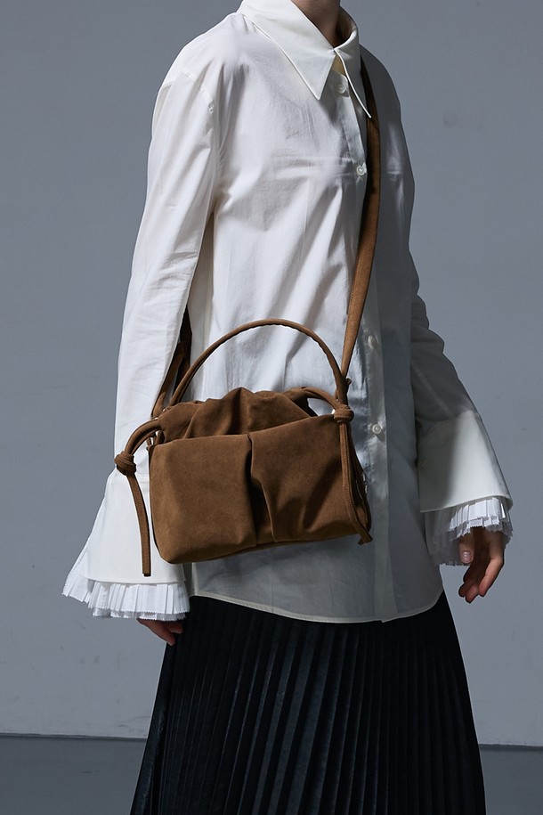 DEAR BAG SMALL SUEDE CAMEL (디어백 스몰 스웨이드 카멜) 숄더백은 부드러운 스웨이드 소재의 카멜 컬러로, 미니멀하면서도 클래식한 스타일을 연출합니다. 가방 전면에 리본 디테일이 여성스러운 포인트를 더하며, 사각 쉐입과 숄더 스트랩으로 실용성을 높였습니다. 마그네틱 잠금 방식으로 간편하게 여닫을 수 있어 데이트룩, 모임룩 등 다양한 TPO에 활용 가능합니다. 디어백 시리즈 특유의 세련된 디자인으로 일상 속에서 스타일리시함을 더해보세요.
