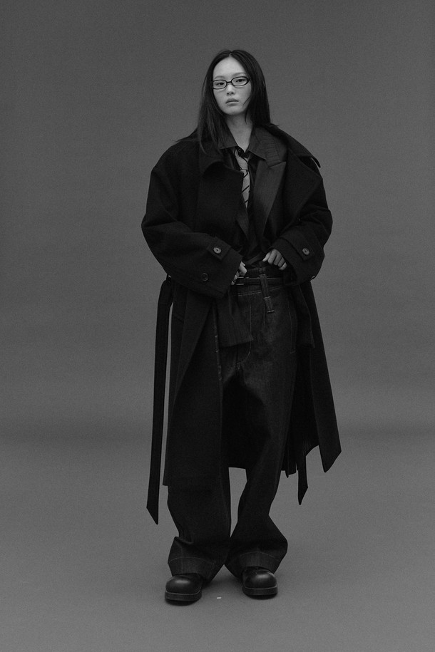 네이비 컬러의 오버사이즈드 웨이스트 벨트 코트입니다. 울과 캐시미어 혼방 소재로 제작되어 부드러운 촉감과 두꺼운 두께로 뛰어난 보온성을 자랑합니다. 클래식하고 모던한 디자인으로, 롱 기장의 더블 코트이며, 허리 부분의 웨이스트 벨트가 특징입니다. 뒷중심 벤트, 소매 밴드 버튼, 암홀 패브릭 밴드와 같은 디테일이 돋보이며, 안감은 폴리에스터와 레이온으로 마감되었습니다. 출근룩, 오피스룩, 겨울 데일리룩 등 다양한 TPO에 활용 가능하며, 미니멀하고 시크한 스타일을 연출하기 좋습니다.
