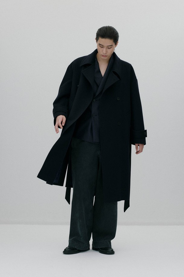 네이비 컬러의 오버사이즈드 웨이스트 벨트 코트입니다. 울과 캐시미어 혼방 소재로 제작되어 부드러운 촉감과 두꺼운 두께로 뛰어난 보온성을 자랑합니다. 클래식하고 모던한 디자인으로, 롱 기장의 더블 코트이며, 허리 부분의 웨이스트 벨트가 특징입니다. 뒷중심 벤트, 소매 밴드 버튼, 암홀 패브릭 밴드와 같은 디테일이 돋보이며, 안감은 폴리에스터와 레이온으로 마감되었습니다. 출근룩, 오피스룩, 겨울 데일리룩 등 다양한 TPO에 활용 가능하며, 미니멀하고 시크한 스타일을 연출하기 좋습니다.
